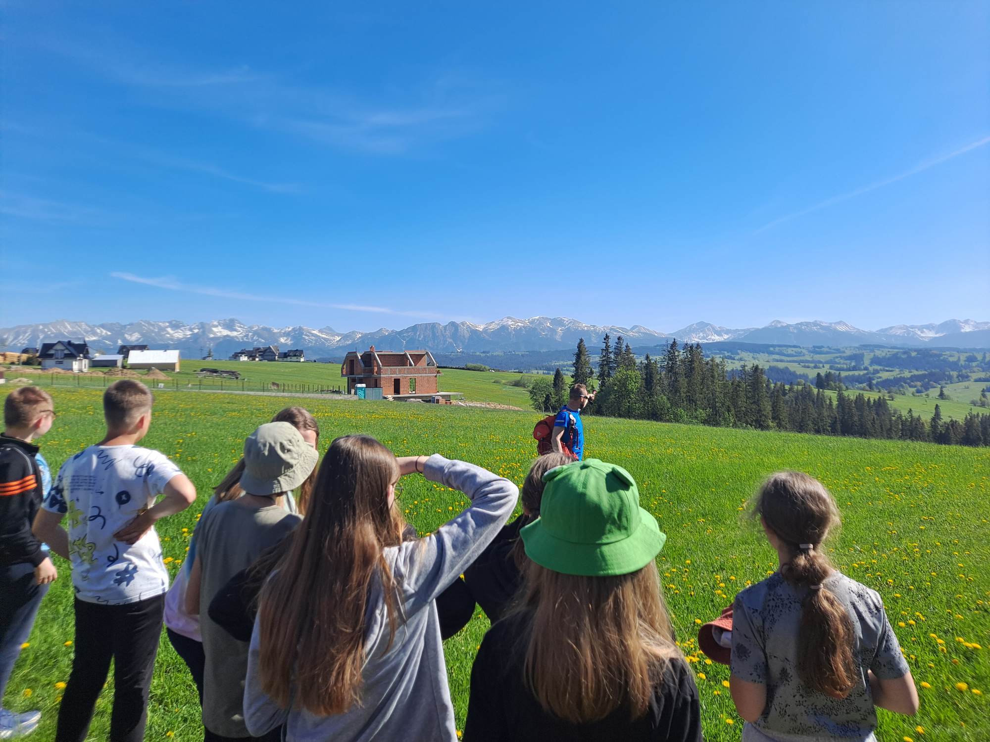 Uczniowie obserwują panoramę Tatr i Beskidu Żywieckiego z Bachledówki  - wzniesienia na Pogórzu Spisko - Gubałowskim koło Zakopanego.