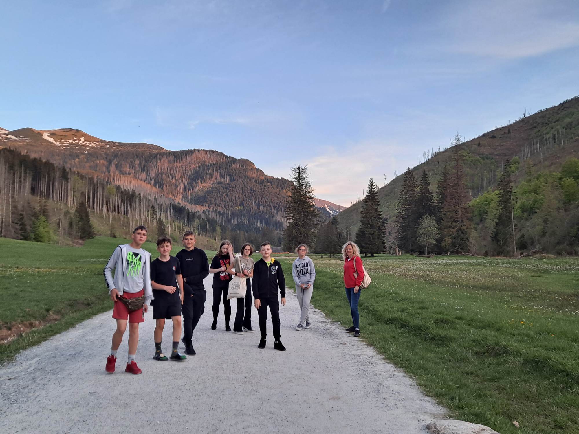 Grupa młodzieży szkolnej na wieczornym spacerze Doliną Kościeliską w Tatrach.