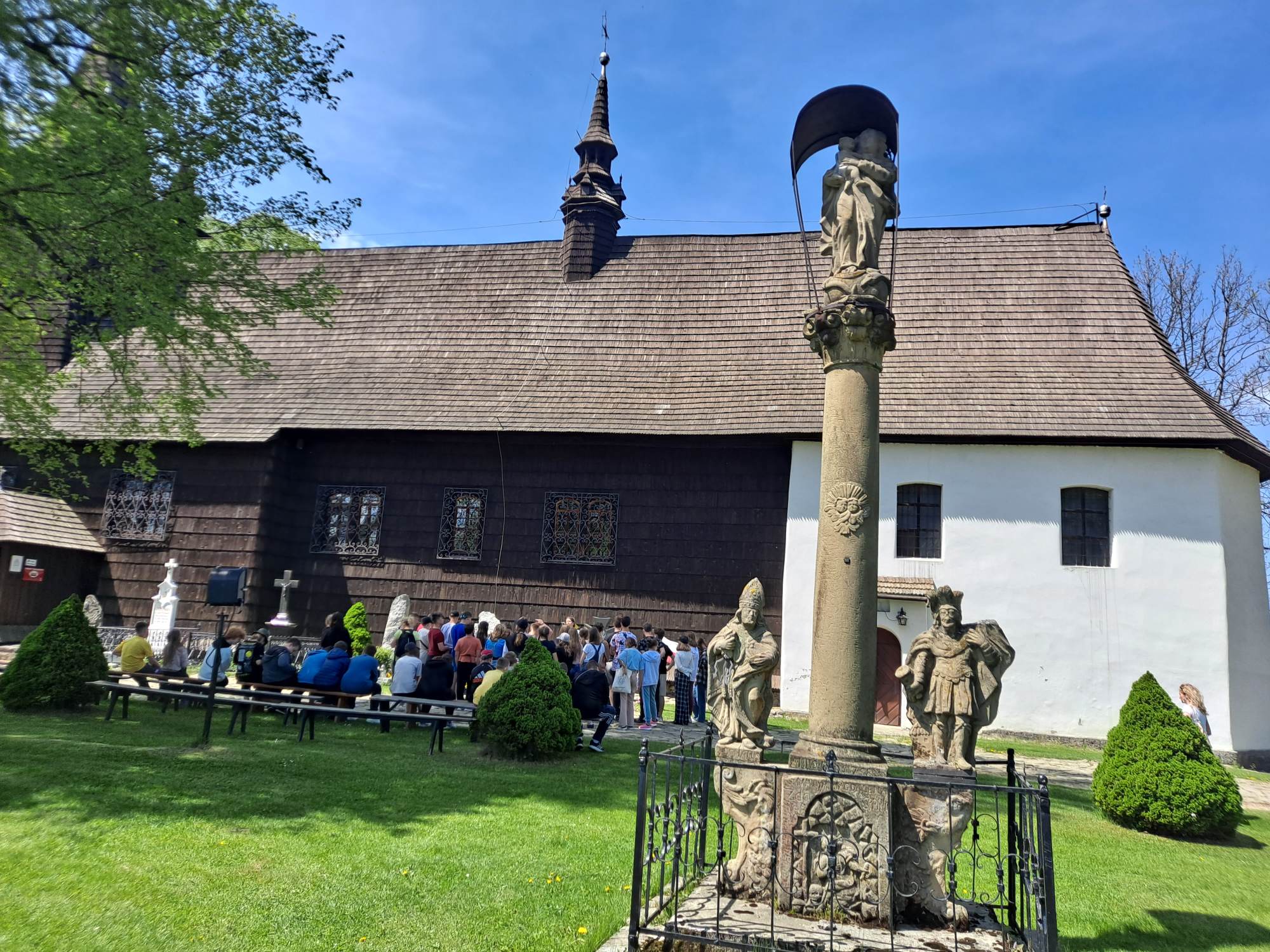Uczniowie słuchają przewodnika opowiadającego o historii XVII. wiecznego drenianego kościoła św. Jana Chrzciciela w Orawce