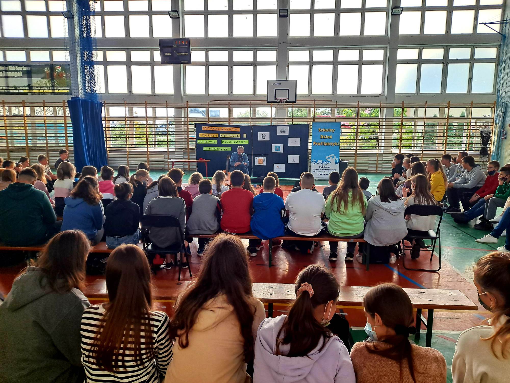 Uczniowie w hali sportowej na spotkaniu z aktorem i pieśniarzem Lechem Dyblikiem, zorganizowanym w ramach Szkolnego Dnia Profilaktyki